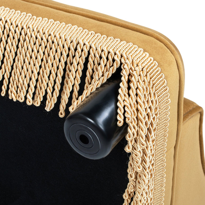 A close-up view of the bottom corner of a yellow pet sofa, showing the non-slip rubber foot pad, bottom lining fabric, and dangling fringe trim.
