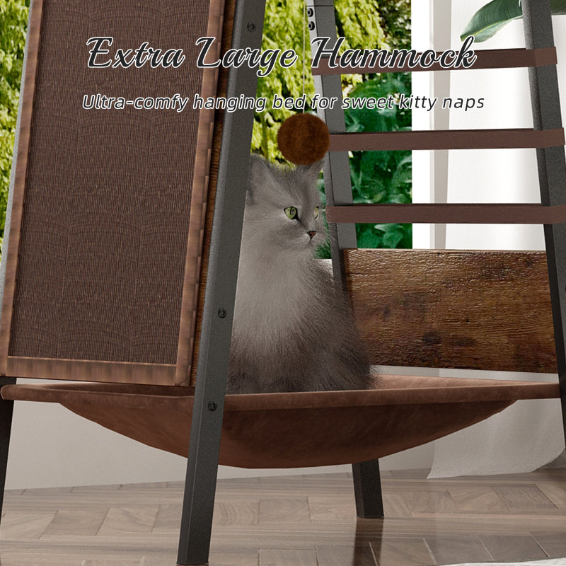 Close-up view of the extra large brown hanging hammock bed at the base of the rustic cat tree tower with a long-haired fluffy cat sitting inside next to a sisal scratching mat