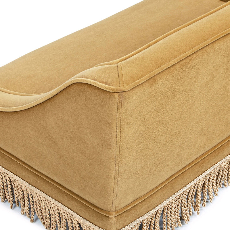 A close-up view highlighting the backrest stitching, smooth velvet fabric, and bottom tassel trim of a mustard yellow pet sofa bed.
